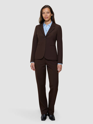 En kvinne som har på seg en «Women’s Essential Fitted Blazer» i fargen «Espresso» over en lyseblå skjorte med knapper.