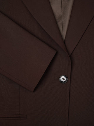 Essential-blazer for kvinner i espresso-farget teknisk stoff, med én knapp foran og skrå krage.