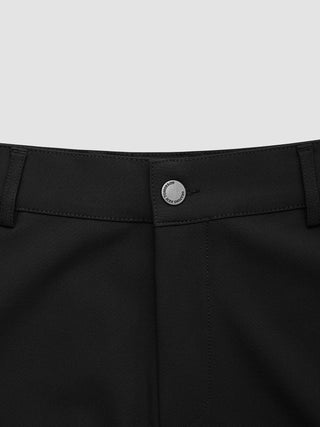 Nærbilde av linningen og knappen på Essential Shorts Black, med merketeksten «New Tomorrow» på metallknappen.