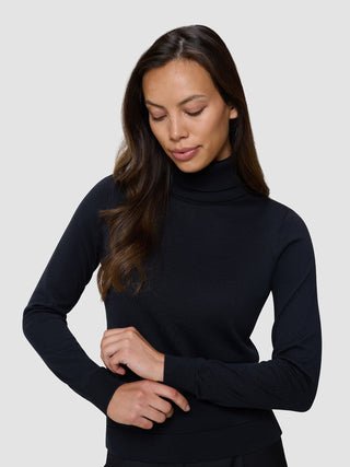 En kvinne som har på seg en svart, finstrikket turtleneck.