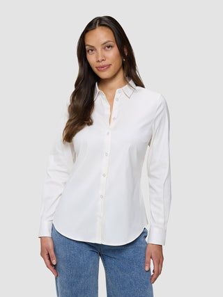 Kvinne iført en Women’s Oxford Shirt White Orchid Slim, som er stappet inn i blå jeans.