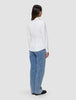 En kvinne sett bakfra, kledd i en Women’s Oxford Shirt White Orchid Slim og blå jeans.