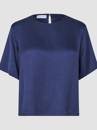 Amara-bluse for damer i marineblå sateng med en diskret krøllete effekt og en liten knappelukking bak.