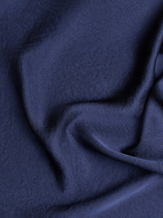 Et nærbilde av stoffet med krøllete effekt på Amara-blusen for damer i marineblått.