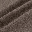 Nærbilde av de brune Atelier Pants Relaxed Dark Beige i brutt twill-stoff med synlig veving og diagonale folder.