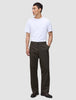En mann i en hvit T-skjorte og Atelier Pants Relaxed Dark Brown, som gjenspeiler en stil preget av skandinavisk design.