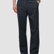 En person som har på seg mørkeblå Atelier Pants Relaxed Dark Navy i brutt twill og sorte skinnloafers.