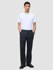 En mann i hvit T-skjorte, mørk marineblå Atelier Pants Relaxed og svarte loafers, som gjenspeiler det rene skandinaviske designet.