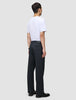 En person sett bakfra, kledd i en hvit T-skjorte og mørk marineblå Atelier Pants Relaxed.