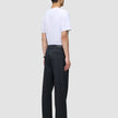 En person sett bakfra, kledd i en hvit T-skjorte og mørk marineblå Atelier Pants Relaxed.