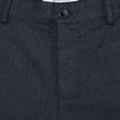 Nærbilde av de mørkeblå Atelier Pants Relaxed-buksene, som viser stoffet i brutt twill, knappelukking og innvendig merkelapp.