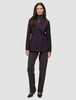 En kvinne som har på seg en Women’s Avira Blazer Burgundy Berry over en grå turtleneck og mørke bukser med svarte høyhælte sko.