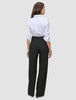 En kvinne sett bakfra, iført en hvit skjorte med knapper og svarte Women’s Avira Pants Wide Black-bukser med høy midje.