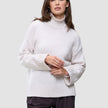Kvinne iført en Women’s Chunky Soft Wool Knit Turtleneck Sugar Melange, en oversized kremfarget ullgenser.
