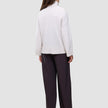 Bakfra-bilde av en person iført en tykk, myk damestrikket turtleneck i Sugar Melange og mørke bukser med vide ben.