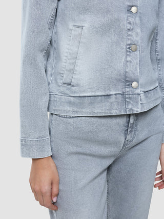 En person som har på seg en klassisk damedenimjakke i lysegrå vasket utførelse og matchende jeans.