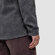 Nærbilde av en person som har på seg en mørkegrå Double Layer Wool Overshirt Regular og brune bukser.