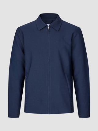 Ease Jacket Blue Nights, en marineblå bomberjakke med krage og glidelås foran i skandinavisk design.