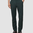 En person som har på seg mørkegrønne Ease Pants Regular Northern Pine og brune lærstøvler.