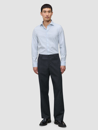 En mann kledd i en Elevated Shirt Regular Classic Blue Striped, mørke bukser og svarte loafers.