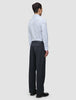 En mann sett i profil har på seg en Elevated Shirt Regular Classic Blue Striped og mørkegrå bukser.
