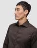 En mann iført en Elevated Shirt Regular Dark Brown i et rent, skandinavisk design.