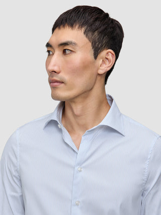 Mann iført en Elevated Shirt Slim Classic Blue Striped i lyseblå og hvit finstripet Pima-bomull.