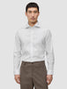 En mann kledd i en Elevated Shirt White Slim i Pima-bomull med spredt krage og brune bukser.