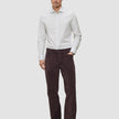 En mann i en Elevated Shirt Slim med lysegrå striper, mørke bukser og mørke loafers.