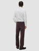 En person sett bakfra, kledd i en Elevated Shirt Slim med lysegrå striper og mørkebrune bukser.