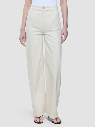En person som har på seg «Women’s Relaxed Jeans» i offwhite og svarte tåsandaler.