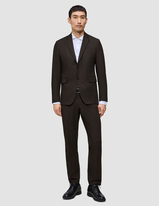 En mann kledd i en Motion Blazer Regular i fargen Cognac, hvit skjorte med krage og svarte dressko.