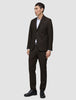 En mann i en Motion Blazer Regular Cognac over en hvit skjorte og svarte dressko.