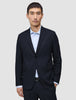 En mann i en Motion Blazer Regular i fargen Midnight Blue over en lyseblå stripete skjorte.