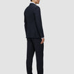 En mann i en midnattsblå Motion Blazer Regular og bukser med 360°-stretch ser til siden.