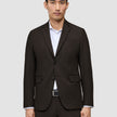 En mann som har på seg en mørkebrun Motion Blazer Slim Cognac over en hvit skjorte med knapper.