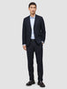 En mann kledd i en Motion Blazer Slim i fargen Midnight Blue, matchende bukser, en lyseblå skjorte og mørke loafers med 360°-stretch.