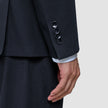 Nærbilde av en mørkeblå Motion Blazer Slim Midnight Blue-erme med fire mansjettknapper og en stripete skjorte under.