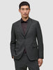 En mann som har på seg en grå Motion Blazer Slim Pepper Grey over en mørk skjorte med knapper.