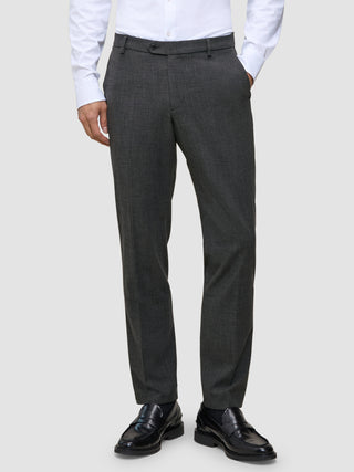 En mann i en hvit skjorte med knapper, svarte skinnloafers og Motion Suit-bukser i Regular-passform i fargen Pepper Grey.