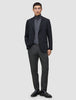 En mann i svart blazer, grå turtleneck, Motion Suit-bukser i Regular-passform i fargen Pepper Grey og svarte loafers.