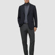 En mann i svart blazer, grå turtleneck, Motion Suit-bukser i Regular-passform i fargen Pepper Grey og svarte loafers.
