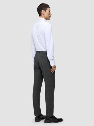 En mann i hvit skjorte og grå Motion Suit-bukse i Regular-passform i fargen Pepper Grey, sett bakfra.