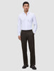 En mann i en hvit skjorte med knapper og Motion Suit-bukser i modellen Relaxed Cognac, med et rent skandinavisk design.
