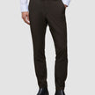 Mørkebrune Motion-dressbukser i slim fit-modell, Slim Cognac, kombinert med en hvit skjorte med knapper og svarte lærstøvler.