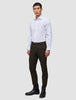 En mann har på seg en hvit skjorte, Motion Suit Pants Slim Cognac og svarte støvler i et rent, skandinavisk design.