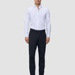 En mann i en hvit skjorte med knapper, midnattsblå Motion Suit Pants Slim og brune loafers.
