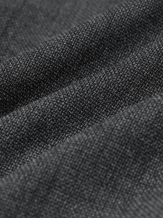 Nærbilde av Motion Suit-bukser i modellen Slim Pepper Grey, laget av strukturert grått stoff med 360°-stretch og myke folder.