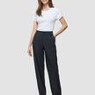 En kvinne kledd i en hvit T-skjorte og «Women Nara Pants Straight Grey Flint».