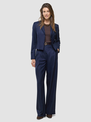 En kvinne kledd i en «Women Raina Short Blazer Night Sky Pinstripe» og matchende bukser med vide ben.